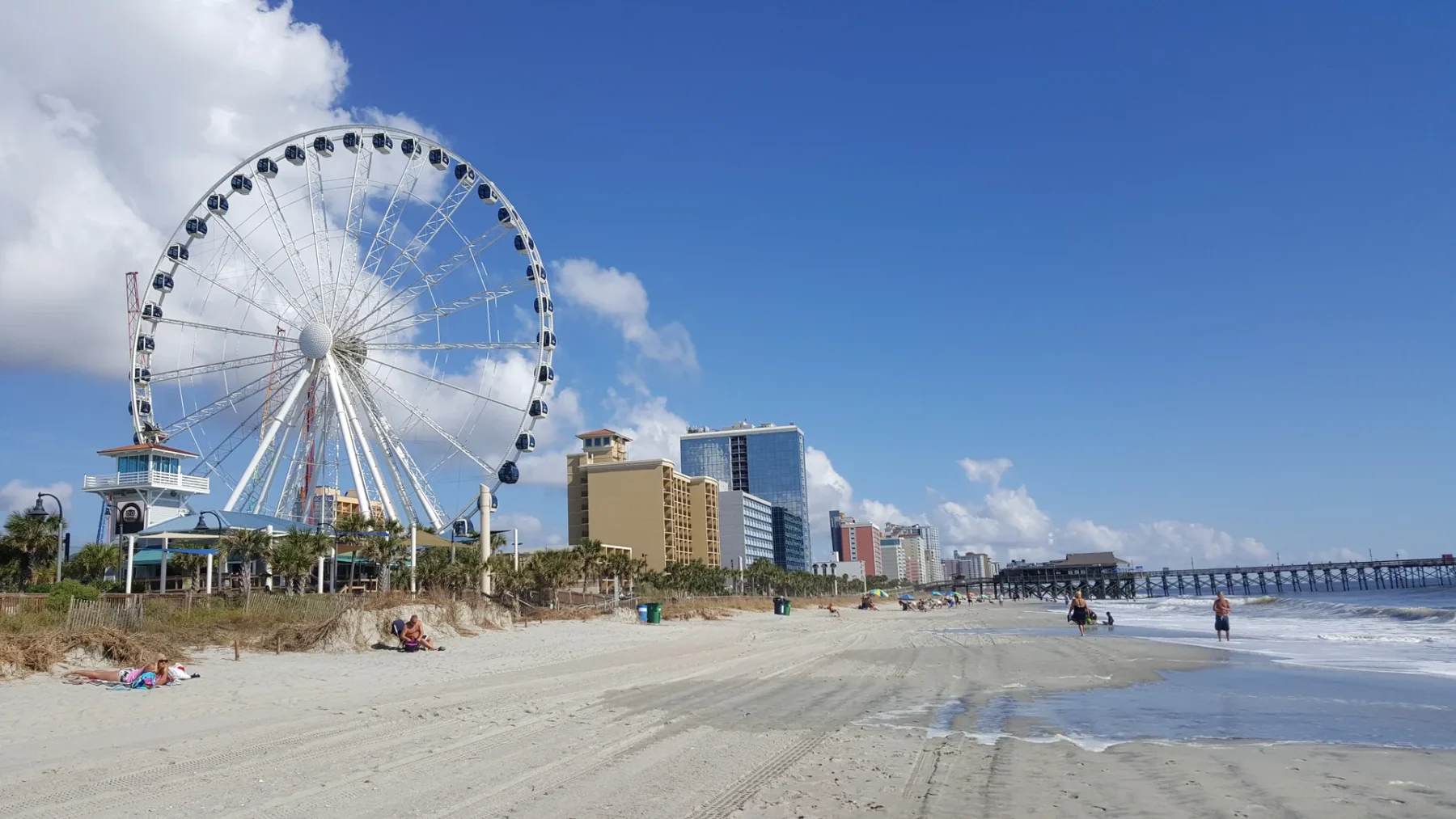 The SkyWheel rises above Myrtle Beach, with broad sand and Pier 14 extending into the Atlantic.