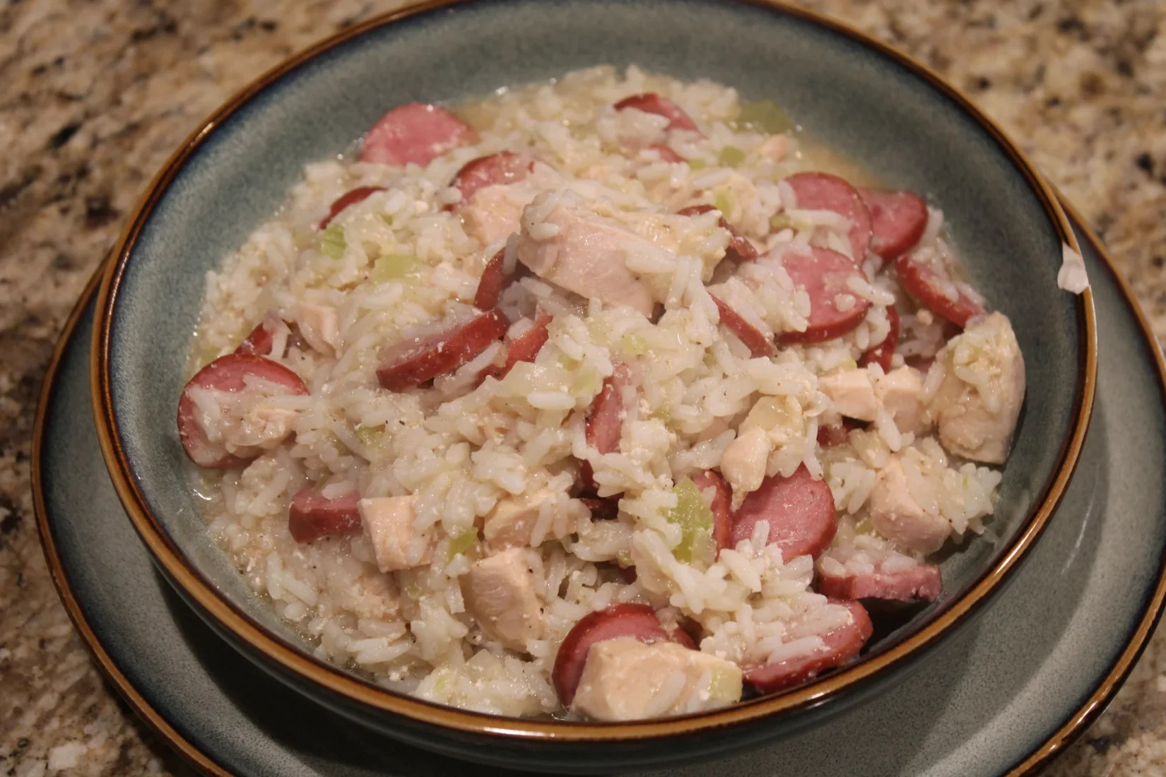 A bowl of homemade chicken bog with rice, chicken and sliced sausage.