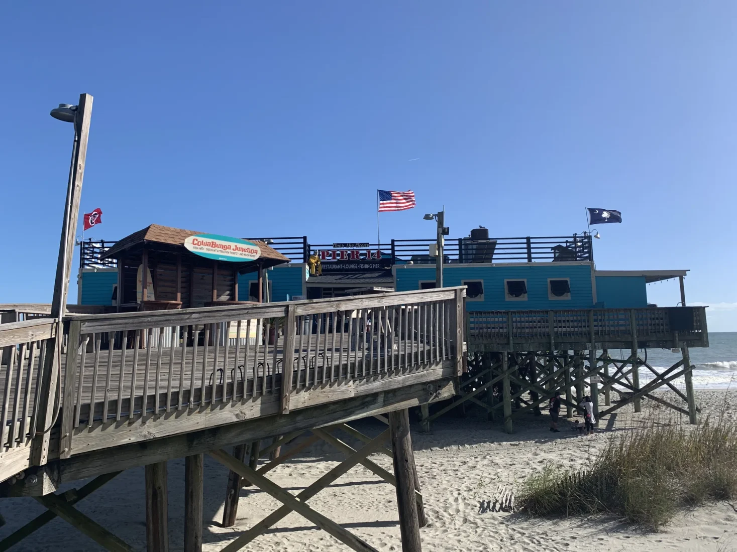 Wooden entrance rails lead to Pier 14 above the sand on the Myrtle Beach oceanfront.